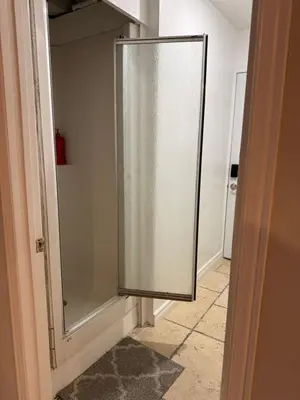 a glass shower door in a room with a hallway at Large private room in Mississauga