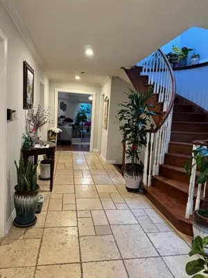 a hallway with a staircase in a home with potted plants at Large private room in Mississauga