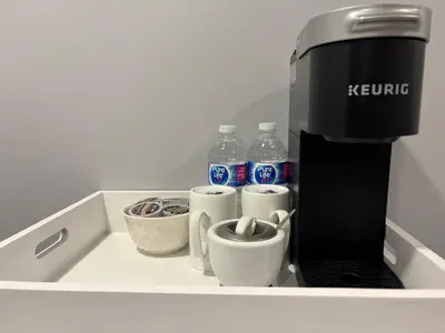 a coffee machine sitting on a counter with cups and water bottles at Bolster in Uxbridge