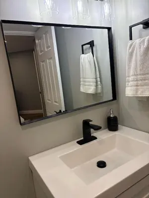 a bathroom sink with a large mirror above it at Bolster in Uxbridge