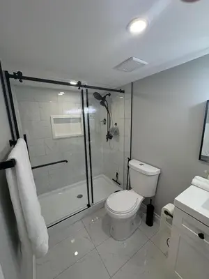a white bathroom with a shower and a toilet at Bolster in Uxbridge