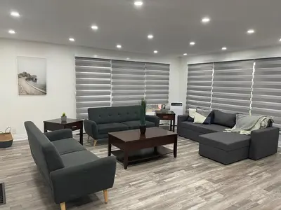 a living room with two couches and a table at Cottage on Muskoka river in Bracebridge