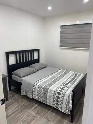 a bedroom with a bed in a white room at Cottage on Muskoka river in Bracebridge
