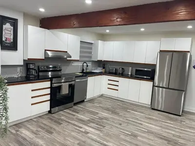 a kitchen with white cabinets and a stainless steel refrigerator at Cottage on Muskoka river in Bracebridge