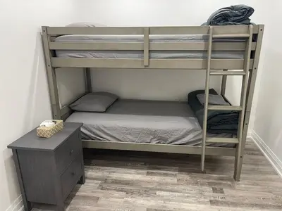 a bedroom with bunk beds with a desk and a bed at Cottage on Muskoka river in Bracebridge