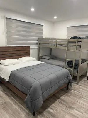 a bedroom with a bed and bunk beds in it at Cottage on Muskoka river in Bracebridge
