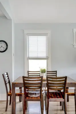 a dining room table with six chairs and a clock at The Finch - 59 Butternut in Cherry Valley