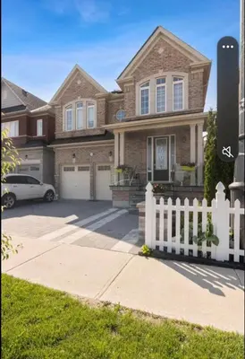 a house with a white fence in front of it at Comfortable & Cozy 2BR Hideaway Basement Appartment in Brampton