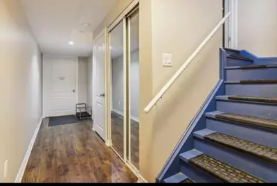 an empty hallway with blue stairs in a house at Comfortable & Cozy 2BR Hideaway Basement Appartment in Brampton
