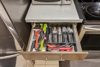 a drawer filled with knives and other tools under a counter at Comfortable & Cozy 2BR Hideaway Basement Appartment in Brampton