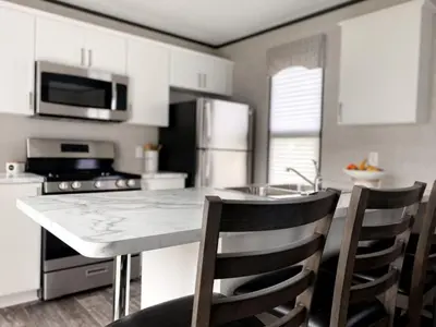 a kitchen with a marble counter top and chairs at The Balmoral at Duck Lake in Carden