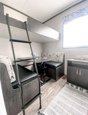 a room with a bunk bed with a table and a ladder at The Balmoral at Duck Lake in Carden