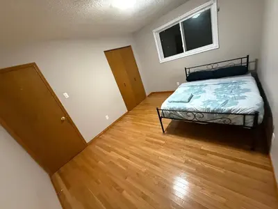 a bedroom with a bed and a wooden floor at UPTOWN WATERLOO-KWC ROOM-Best Location,Lowest Prices in Waterloo
