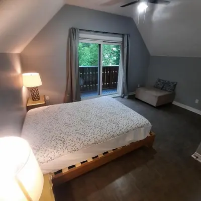 a bedroom with a large bed and a window at Cottage by the beach in Wasaga Beach