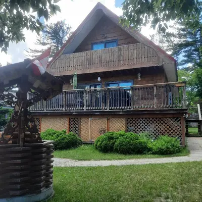 a large house with a deck and a balcony at Cottage by the beach in Wasaga Beach