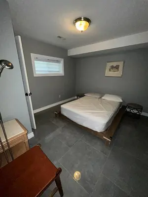 a bedroom with a bed in the corner of the room at Cottage by the beach in Wasaga Beach