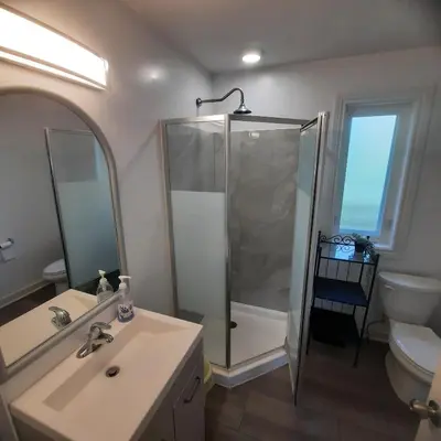 a bathroom with a shower and a sink and a toilet at Cottage by the beach in Wasaga Beach