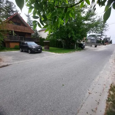 a black car parked on the side of a street at Cottage by the beach in Wasaga Beach