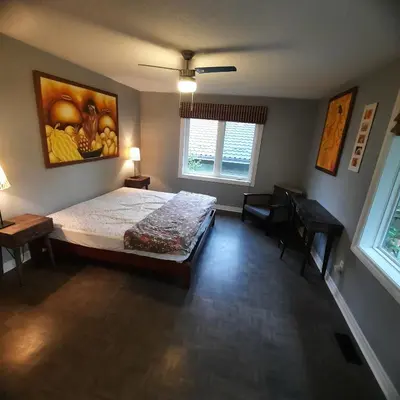 a bedroom with a bed and a painting on the wall at Cottage by the beach in Wasaga Beach