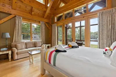 a bedroom with a large bed in a room with windows at Port Cunnington Lodge in Dwight