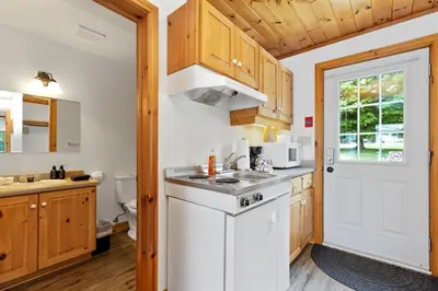 a kitchen with wooden cabinets and a white sink at Port Cunnington Lodge in Dwight