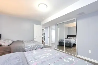a bedroom with two beds and a mirror at Deluxe Apartment in Caledon