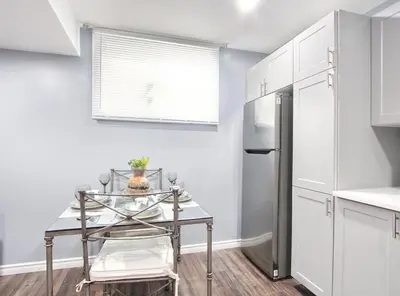 a kitchen with a table and a refrigerator at Deluxe Apartment in Caledon