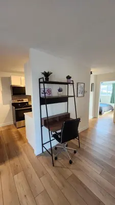 a living room with a chair and a kitchen at ENTIRE 2 BEDROOM APARTMENT by UW RESEARCH PARK - PS5 in Waterloo