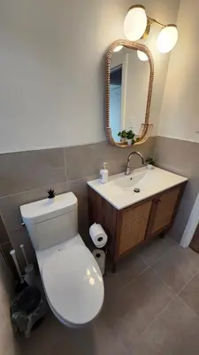 a bathroom with a toilet and a sink and a mirror at ENTIRE 2 BEDROOM APARTMENT by UW RESEARCH PARK - PS5 in Waterloo