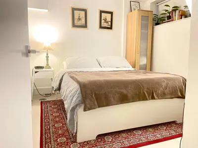 a bedroom with a white bed and a red rug at Excellent Private Suite in Bloor West Village in Toronto