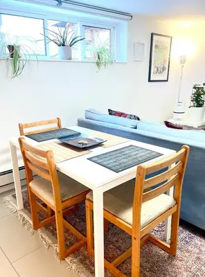 a table and chairs in a living room with a couch at Excellent Private Suite in Bloor West Village in Toronto