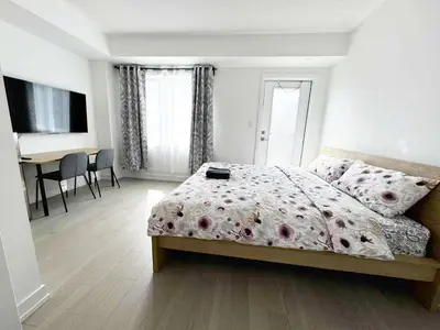 a bedroom with a bed and a desk in it at Modern Private Room Private Bathroom with King Bed with TV and Optional Balcony 10 minutes to Rogers Stadium Midtown Downtown Toronto in Toronto