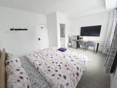 a white bedroom with a bed and a television at Modern Private Room Private Bathroom with King Bed with TV and Optional Balcony 10 minutes to Rogers Stadium Midtown Downtown Toronto in Toronto