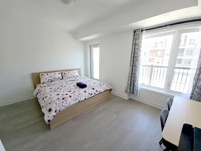 a bedroom with a bed and a large window at Modern Private Room Private Bathroom with King Bed with TV and Optional Balcony 10 minutes to Rogers Stadium Midtown Downtown Toronto in Toronto