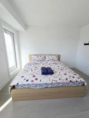a bedroom with a bed with a purple comforter at Modern Private Room Private Bathroom with King Bed with TV and Optional Balcony 10 minutes to Rogers Stadium Midtown Downtown Toronto in Toronto