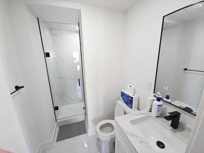 a white bathroom with a sink and a shower at Modern Private Room Private Bathroom with King Bed with TV and Optional Balcony 10 minutes to Rogers Stadium Midtown Downtown Toronto in Toronto