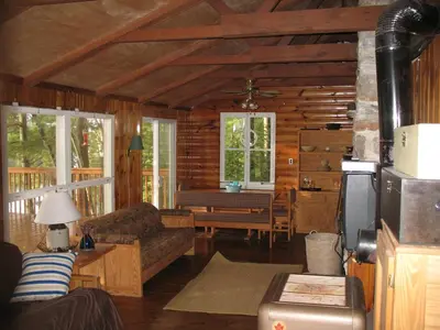 a living room with a couch and a table at Private Lakefront Family Cottage with Tennis Court in Kinmount