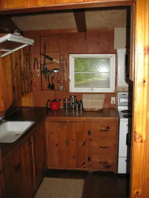 a kitchen with wooden cabinets and a window at Private Lakefront Family Cottage with Tennis Court in Kinmount