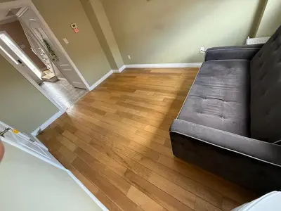a couch in a living room with a wooden floor at HOMESTAY NEXT TO SQUARE ONE MALL- 5 Mins Airport-24 HRS CHECKIN-MAJOR COST CUT in Mississauga