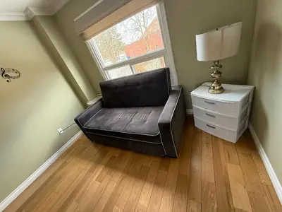 a black leather chair sitting in a room with a window at HOMESTAY NEXT TO SQUARE ONE MALL- 5 Mins Airport-24 HRS CHECKIN-MAJOR COST CUT in Mississauga