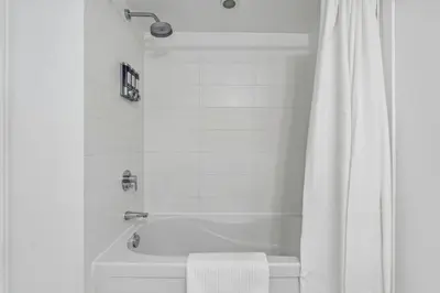 a white bathroom with a tub and a white shower curtain at Elegant Condo, Toronto Views , CityPlace Downtown in Toronto