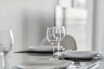 a table with two wine glasses and plates on it at Elegant Condo, Toronto Views , CityPlace Downtown in Toronto
