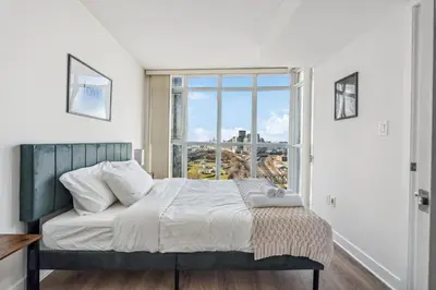 a bedroom with a bed and a large window at Elegant Condo, Toronto Views , CityPlace Downtown in Toronto