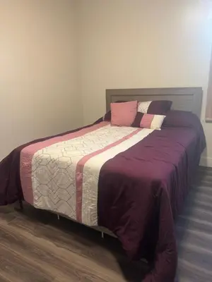 a bedroom with a large bed with purple sheets and pillows at Decor Dreams in Stayner