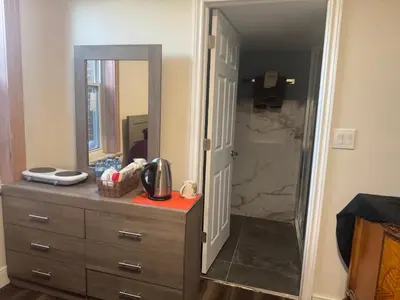 a bathroom with a dresser and a large mirror at Decor Dreams in Stayner