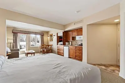 a bedroom with a large bed and a kitchen at Peaceful Escape King Bed and Outdoor Activities in Edgar