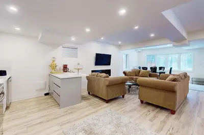 a living room with chairs and a table and a kitchen at Luxhome25 in Aurora