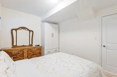 a white bedroom with a bed and a mirror at Luxhome25 in Aurora
