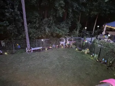a yard at night with a fence and lights at Luxhome25 in Aurora