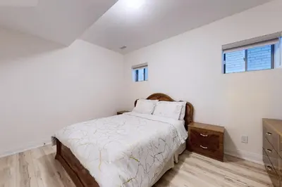 a white bedroom with a bed and a dresser at Luxhome25 in Aurora